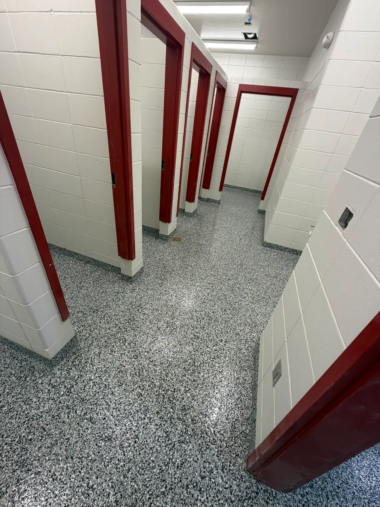 Flake epoxy floor in a locker room corridor with red door frames